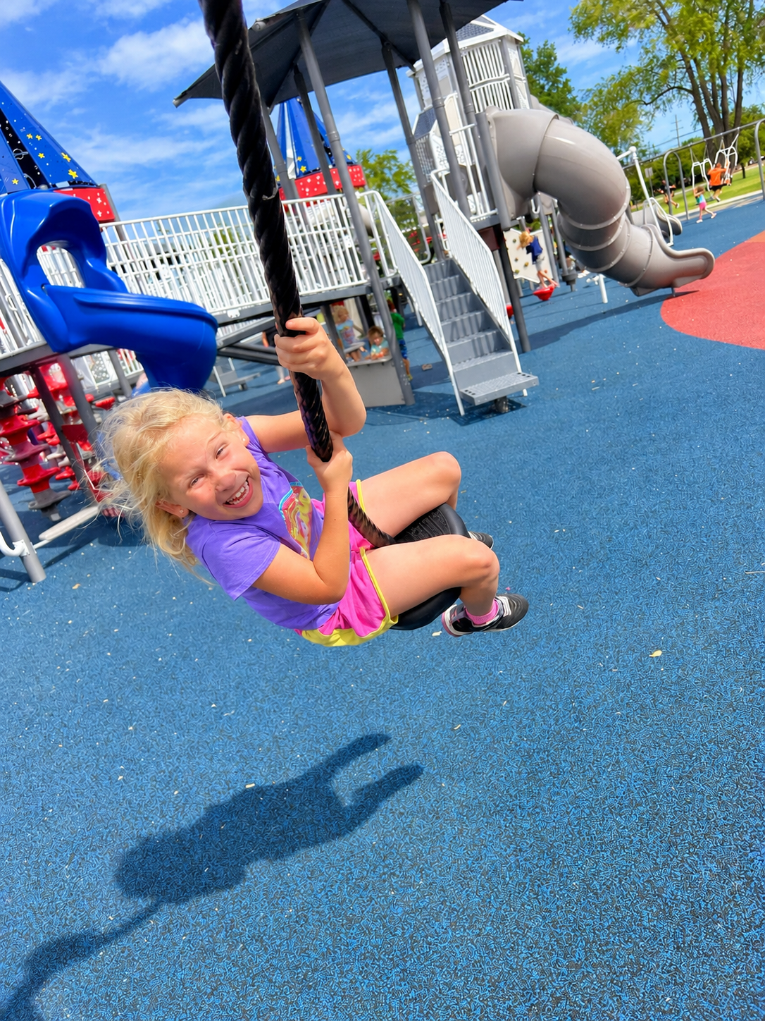 Child enjoying a tire swing at the park